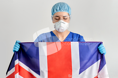 Image of doctor in goggles and mask holding flag of england