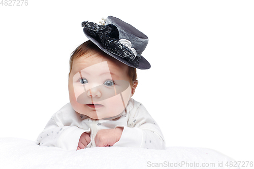 Image of beautiful baby girl in fancy hat on white blanket