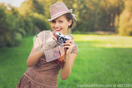 Image of beautiful teen age girl with retro camera