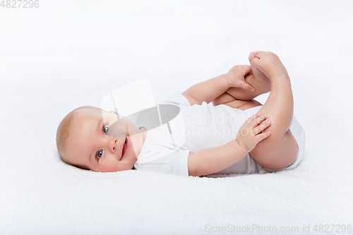 Image of happy beautiful baby girl in white body suit
