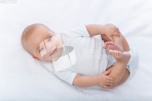 Image of happy beautiful baby girl in white body suit