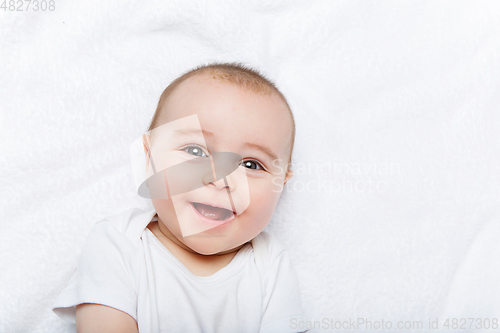 Image of happy beautiful baby boy in white body suit