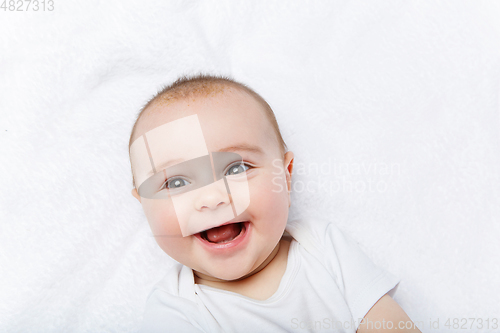 Image of happy beautiful baby boy in white body suit