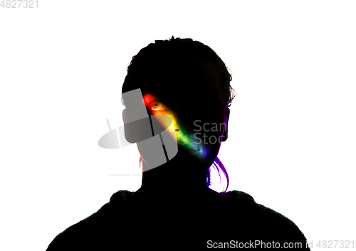 Image of Dramatic portrait of a girl in the dark on white studio background with rainbow colored line