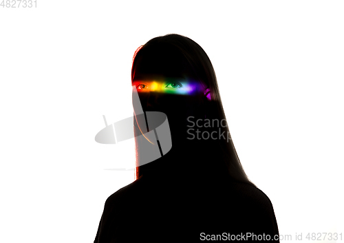 Image of Dramatic portrait of a girl in the dark on white studio background with rainbow colored line