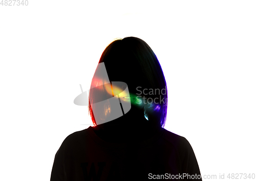 Image of Dramatic portrait of a girl in the dark on white studio background with rainbow colored line