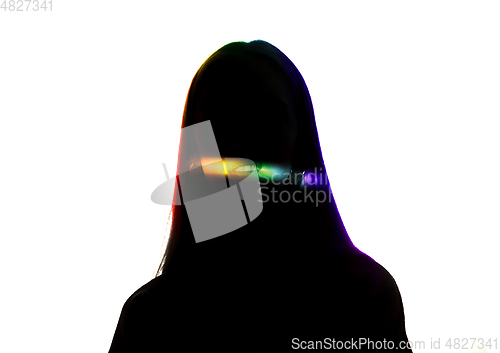 Image of Dramatic portrait of a girl in the dark on white studio background with rainbow colored line