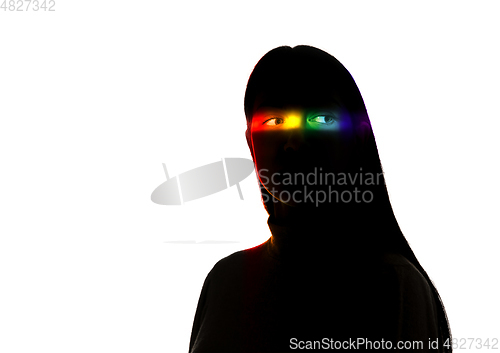 Image of Dramatic portrait of a girl in the dark on white studio background with rainbow colored line