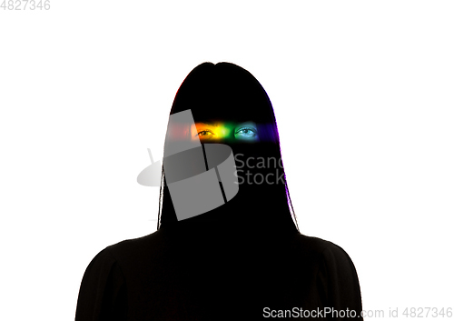 Image of Dramatic portrait of a girl in the dark on white studio background with rainbow colored line