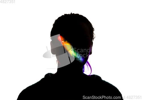 Image of Dramatic portrait of a girl in the dark on white studio background with rainbow colored line