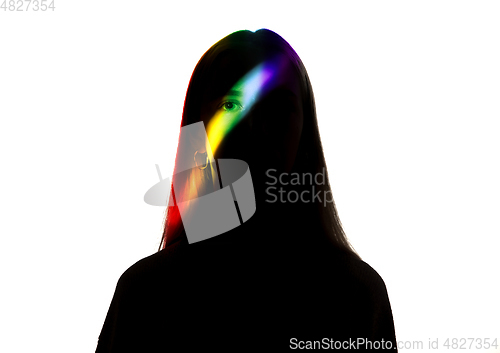 Image of Dramatic portrait of a girl in the dark on white studio background with rainbow colored line