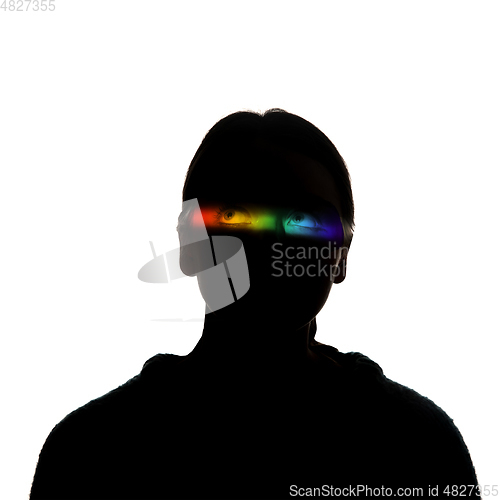 Image of Dramatic portrait of a girl in the dark on white studio background with rainbow colored line
