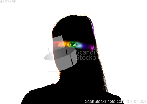 Image of Dramatic portrait of a girl in the dark on white studio background with rainbow colored line