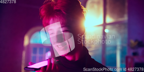 Image of Cinematic portrait of handsome young man in neon lighted interior