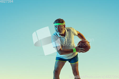 Image of Senior man playing basketball in sportwear on gradient background and neon light