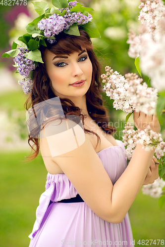 Image of beautiful girl in purple dress with lilac flowers