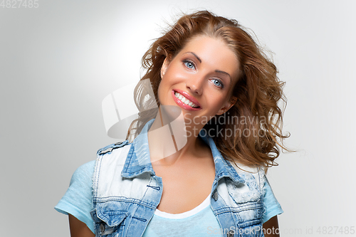 Image of beautiful happy girl in blue jeans jacket