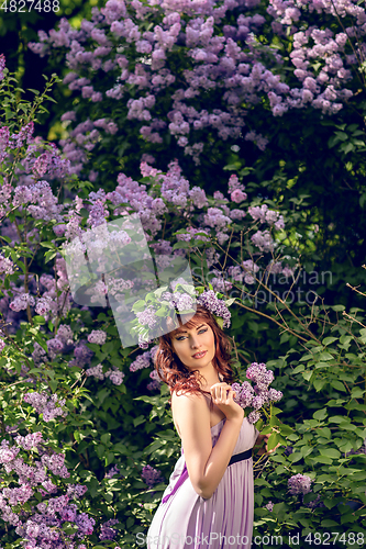 Image of beautiful girl in purple dress with lilac flowers