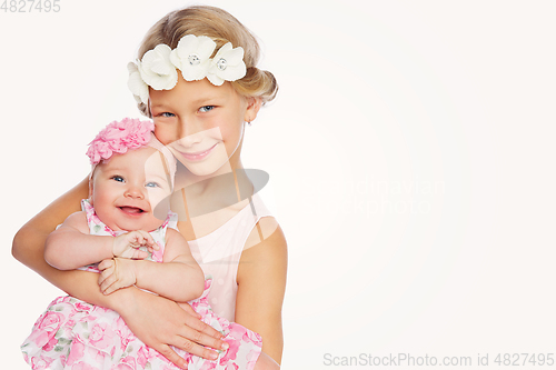 Image of happy beautiful girl with baby baby sister