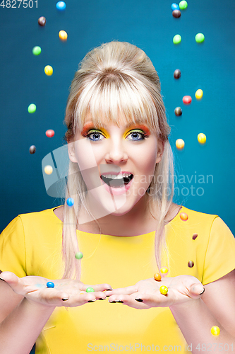 Image of beautiful blond girl with many colorful candies