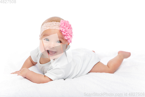 Image of happy beautiful baby girl in white body suit