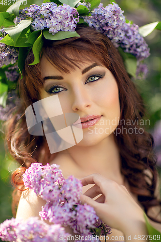 Image of beautiful girl in purple dress with lilac flowers