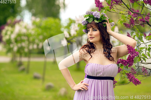 Image of beautiful girl in purple dress with lilac flowers