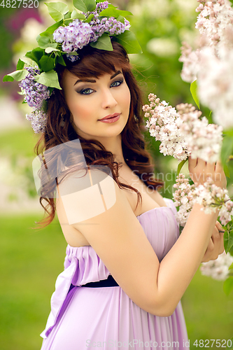 Image of beautiful girl in purple dress with lilac flowers