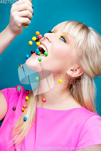 Image of beautiful blond girl with many colorful candies