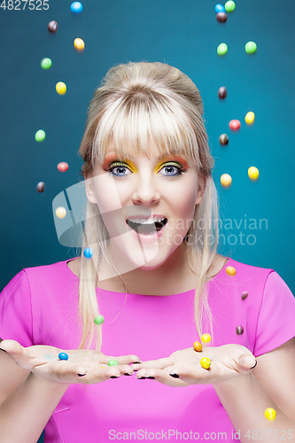 Image of beautiful blond girl with many colorful candies