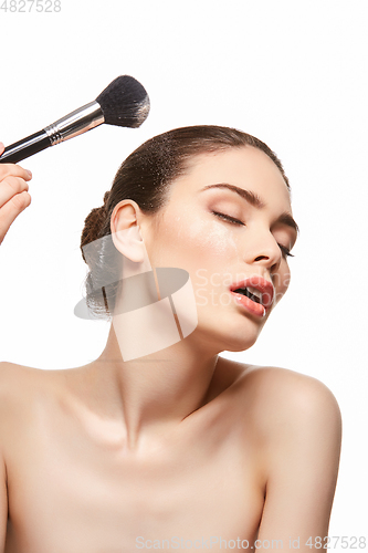 Image of girl applying powder on face isolated on white