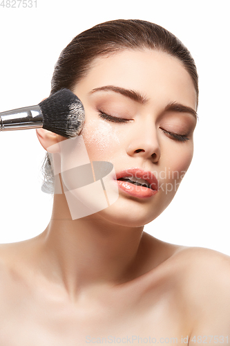 Image of girl applying powder on face isolated on white