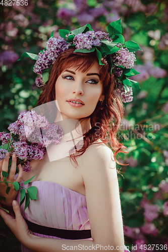 Image of beautiful girl in purple dress with lilac flowers