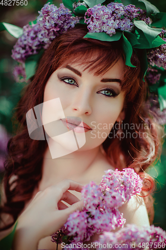 Image of beautiful girl in purple dress with lilac flowers