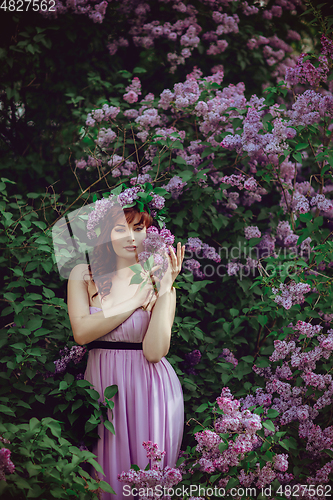 Image of beautiful girl in purple dress with lilac flowers