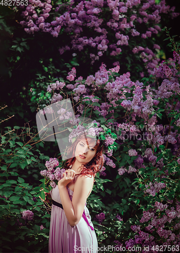 Image of beautiful girl in purple dress with lilac flowers