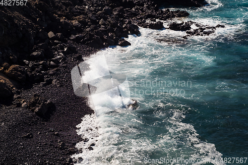 Image of beautiful view on ocean water and black lava sand