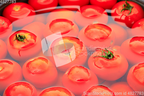 Image of tomatoes in the water prepared for preservation