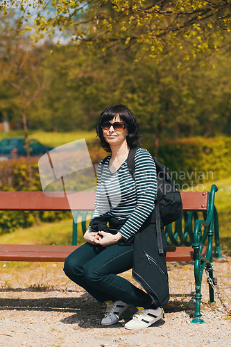 Image of tired Middle age woman resting on bench