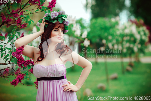 Image of beautiful girl in purple dress with lilac flowers