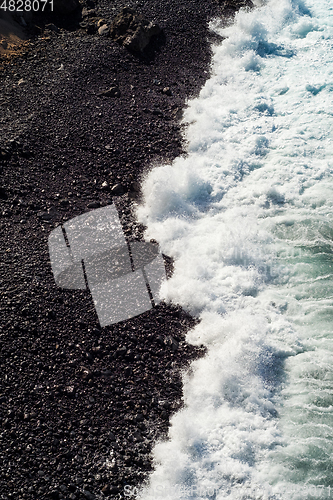 Image of beautiful view on ocean water and black lava sand