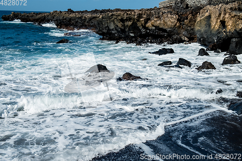 Image of beautiful view on ocean water and black lava sand