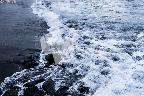 Image of beautiful view on ocean water and black lava sand