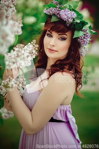 Image of beautiful girl in purple dress with lilac flowers