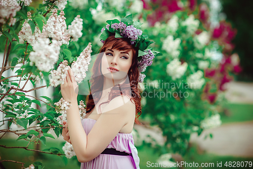 Image of beautiful girl in purple dress with lilac flowers