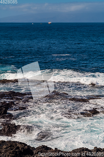 Image of beautiful view on ocean water and black lava sand