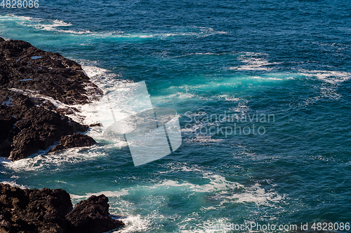 Image of beautiful view on ocean water and black lava sand