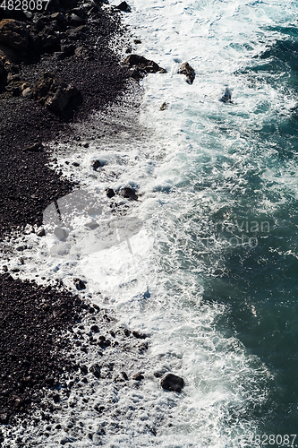 Image of beautiful view on ocean water and black lava sand