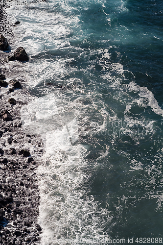 Image of beautiful view on ocean water and black lava sand