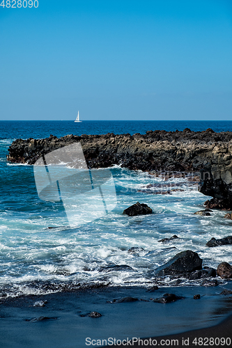 Image of beautiful view on ocean water and black lava sand